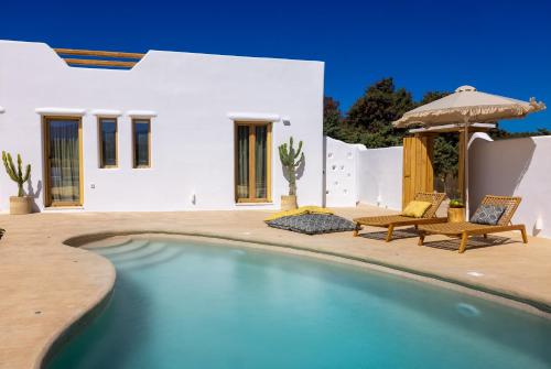 a swimming pool in front of a white house at Villa Alyko in Aliko Beach