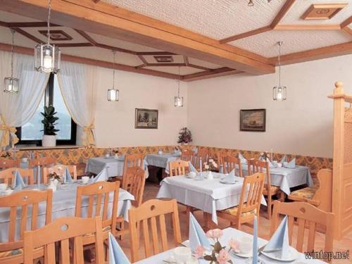 a dining room with tables and chairs in a room at Hotel Landgasthof Hacker in Zachenberg