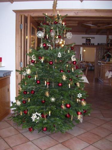 a christmas tree with ornaments on it in a room at Hotel Landgasthof Hacker in Zachenberg