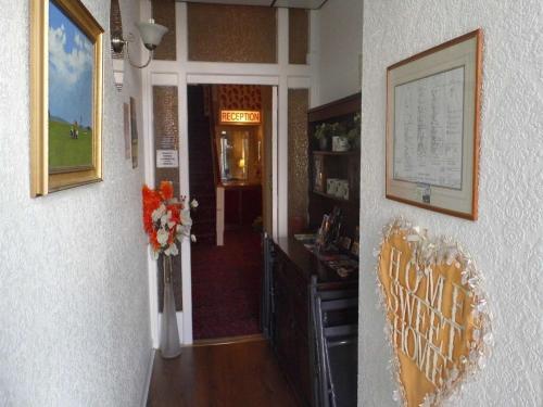 un couloir menant à l'aoyer avec un vase de fleurs dans l'établissement The Pembroke, à Blackpool