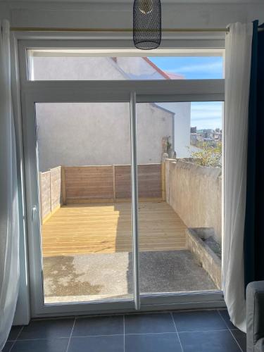 d'une porte coulissante en verre avec vue sur un balcon. dans l'établissement Loft Boulonnais, à Boulogne-sur-Mer