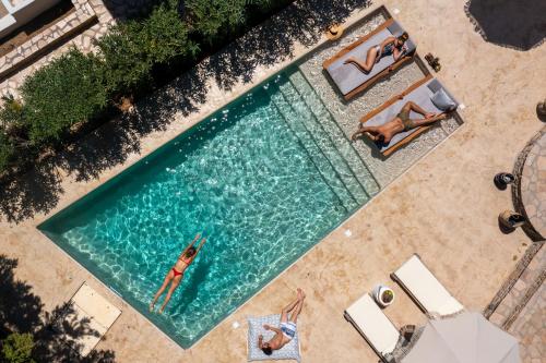 an overhead view of two people swimming in a swimming pool at Villa Alyko in Aliko Beach