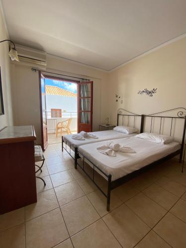 a bedroom with a bed and a balcony at Amazones Village Suites in Hersonissos