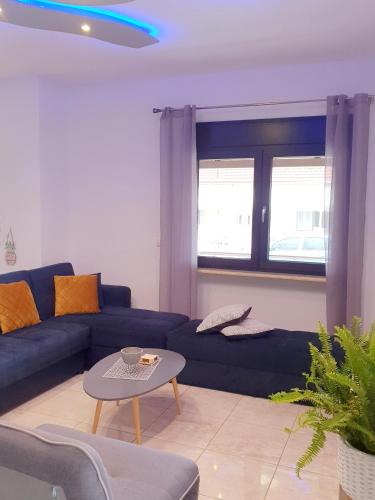 a living room with a blue couch and a table at Tom's House in Néa Karváli