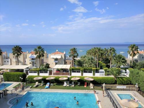 - une vue sur la piscine d'un complexe avec l'océan dans l'établissement Golden Residence Family Resort, à Pefkohori