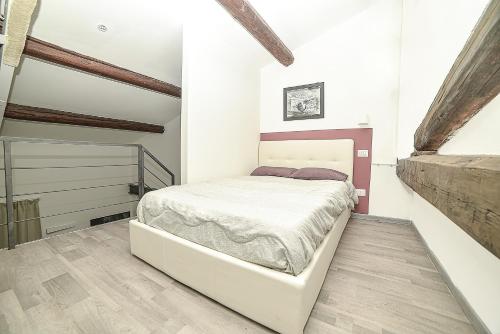 a bedroom with a white bed and a wooden floor at Ruote in Florence