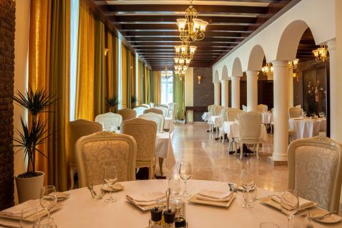فندق راديسون بلو، مسقط في مسقط: غرفة طعام مع طاولات وكراسي بيضاء