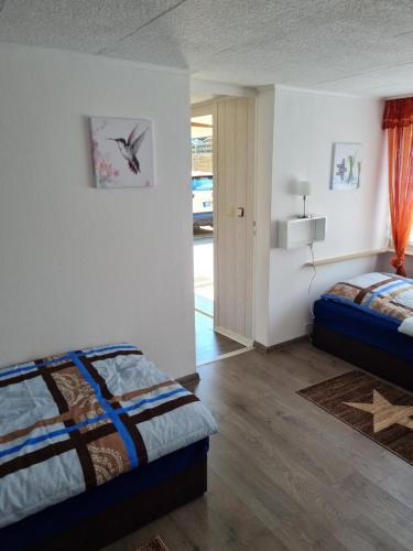 1 dormitorio con 2 camas y puerta a la entrada en Ferienhaus Mandy, en Müllrose