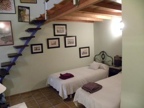 a bedroom with two beds and a staircase at Hoya La Vieja Rural in Tejeda