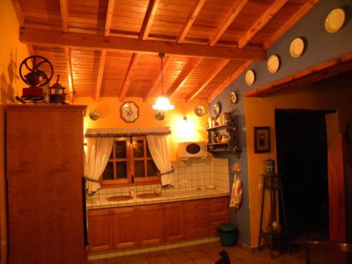 a kitchen with a wooden ceiling and a sink at Hoya La Vieja Rural in Tejeda