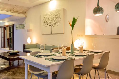 Villa EMMA | heart of Seminyak | 350m Beach في سمينياك: غرفة طعام مع طاولة بيضاء وكراسي