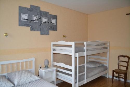 MouchampsにあるChambre d'hôtes la ville en boisのベッドルーム1室(二段ベッド2台、椅子付)