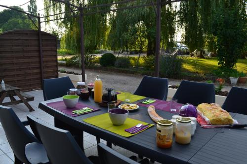 MouchampsにあるChambre d'hôtes la ville en boisのテーブル(上に食べ物と飲み物付)
