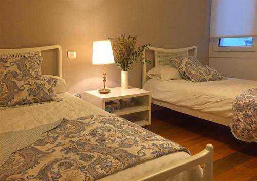 sypialnia z 2 łóżkami i lampką na stole w obiekcie Apartamento Bahía de Plentzia w mieście Plentzia