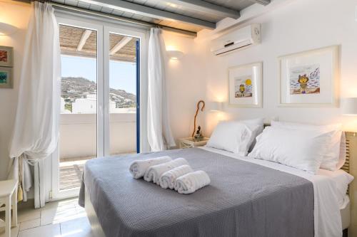 a bedroom with a large bed with towels on it at Ornos Beach House in Ornos