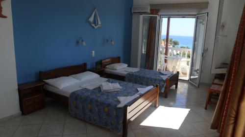 1 Schlafzimmer mit 2 Betten und einem Balkon mit Meerblick in der Unterkunft Patronis Studios in Ammoudi