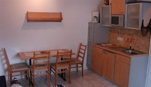 eine Küche mit einem Tisch und einem Waschbecken sowie einem Tisch und Stühlen in der Unterkunft Ferienwohnung Drechsel in Olbernhau
