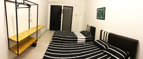Habitación con 3 camas y estante de cristal en Panda Homestay, en Seremban