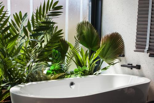 a white bath tub in a bathroom with plants at Hospedium H Cabo Sport in Finisterre