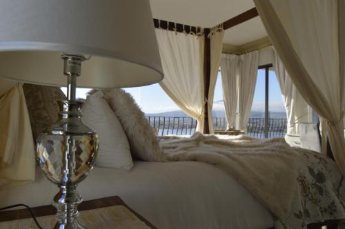 a bedroom with a large bed and a large window at Harbourview Lodge in Gordonʼs Bay