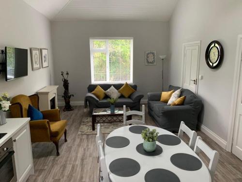 a living room with a couch and a table and chairs at WILLOW COUNTRY COTTAGE in Killarney