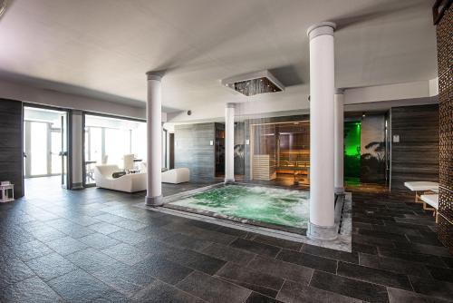 um quarto amplo com uma piscina com colunas em Castello Bonaria Wine & Spa Resort em Campiglia Marittima