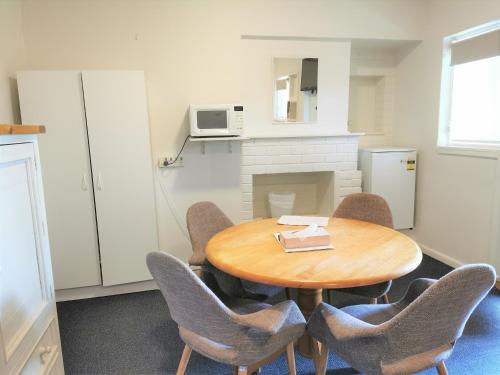 a dining room table with chairs and a microwave at Bathurst Explorers Motel in Bathurst
