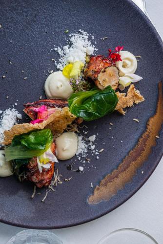 a blue plate with food on a table at Castello Bonaria Wine & Spa Resort in Campiglia Marittima