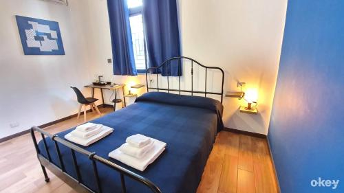 a bedroom with a blue bed with towels on it at I Covi Del Viaggiatore - Bari Politecnico in Bari
