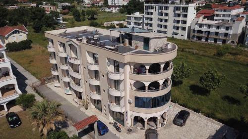 una vista in alto di un grande edificio con auto parcheggiate fuori di Guesthouse Liamra a Ulcinj