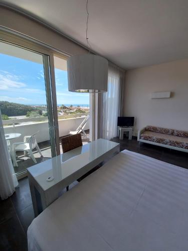 a room with a bed and a table and a couch at Hotel Joseph in Marina di Pietrasanta