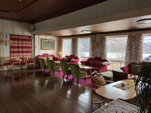 a living room with chairs and tables and windows at Vatnahalsen Høyfjellshotell in Myrdal