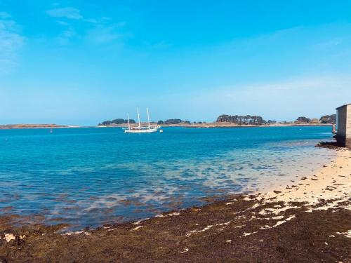 ein Boot liegt im Wasser am Strand in der Unterkunft Chambre/studio douillet en rez-de -jardin in Lannilis