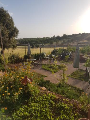 a garden with tables and umbrellas and flowers at Maison d'hôtes Tinwitchi in Azilal