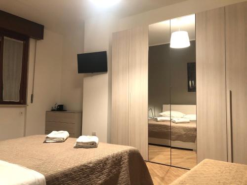 Guest House Brianza Room في ميلانو: غرفة نوم بسريرين ومرآة