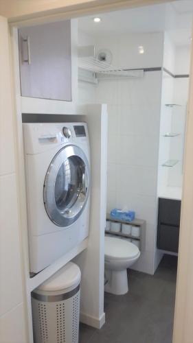 une salle de bain avec machine à laver et toilettes dans l'établissement Studio Villa Emilie, à Cagnes-sur-Mer