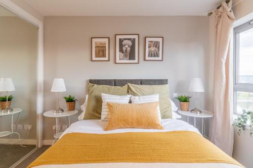 een slaapkamer met een bed met een gele deken bij Luxury Riverview City Centre Apartment in Glasgow