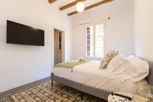 een slaapkamer met een bed en een flatscreen-tv bij Stay Unique Apartments Corsega in Barcelona