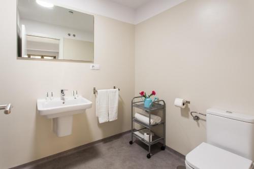 a bathroom with a sink and a toilet and a mirror at Hospedium H Cabo Sport in Finisterre