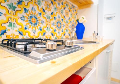 a kitchen counter with a stove and a sink at Hotel & Spa Relais Freedom Club in Massa Lubrense