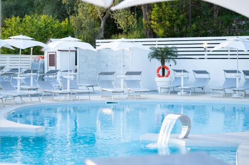a swimming pool with chairs and tables and umbrellas at Hotel & Spa Relais Freedom Club in Massa Lubrense