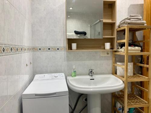 Apartamento Cielo Azul في روكويتاس دي مار: حمام صغير مع مغسلة وغسالة ملابس
