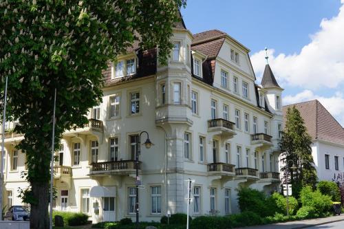 a large white building with balconies on it at Monteurwohnungen in der Residenz am Kurpark in Bad Rothenfelde