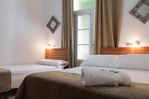 Postel nebo postele na pokoji v ubytování Hostal Colón