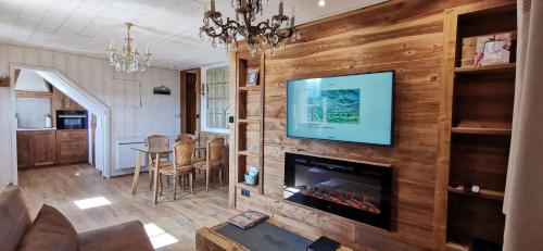 Elle comprend un salon avec une cheminée et une télévision murale. dans l'établissement Le Renne Blanc Pyrénées de France, à Font-Romeu