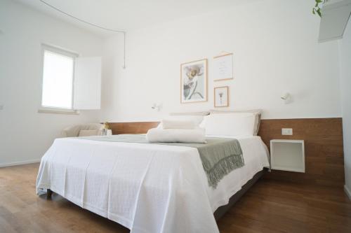 a white bedroom with a large bed with white sheets at B&B La Ferula in Altamura