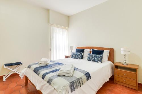 ヴィラモウラにあるApartamento T1 +1のベッドルーム1室(青と白の毛布付きのベッド1台付)