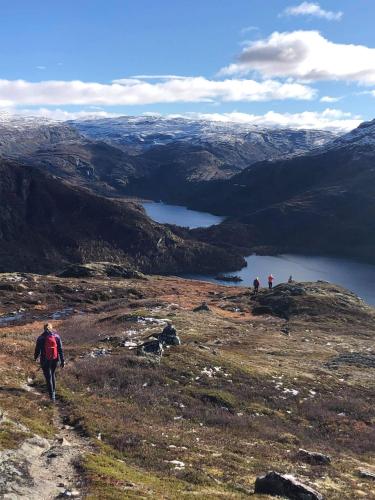 a group of people walking on a hill with a lake at Vatnahalsen Høyfjellshotell in Myrdal