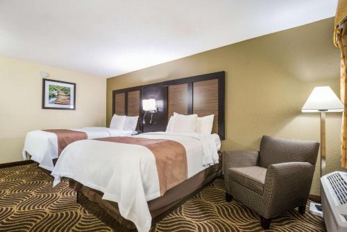 une chambre d'hôtel avec deux lits et une chaise dans l'établissement Quality Inn & Suites Florence - Cincinnati South, à Florence