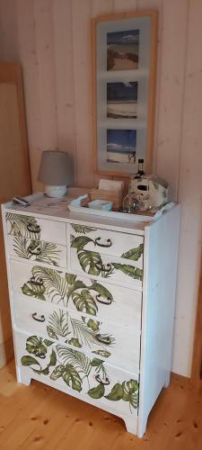 a white dresser with a green and white pattern on it at Mountain Village Room in Habkern